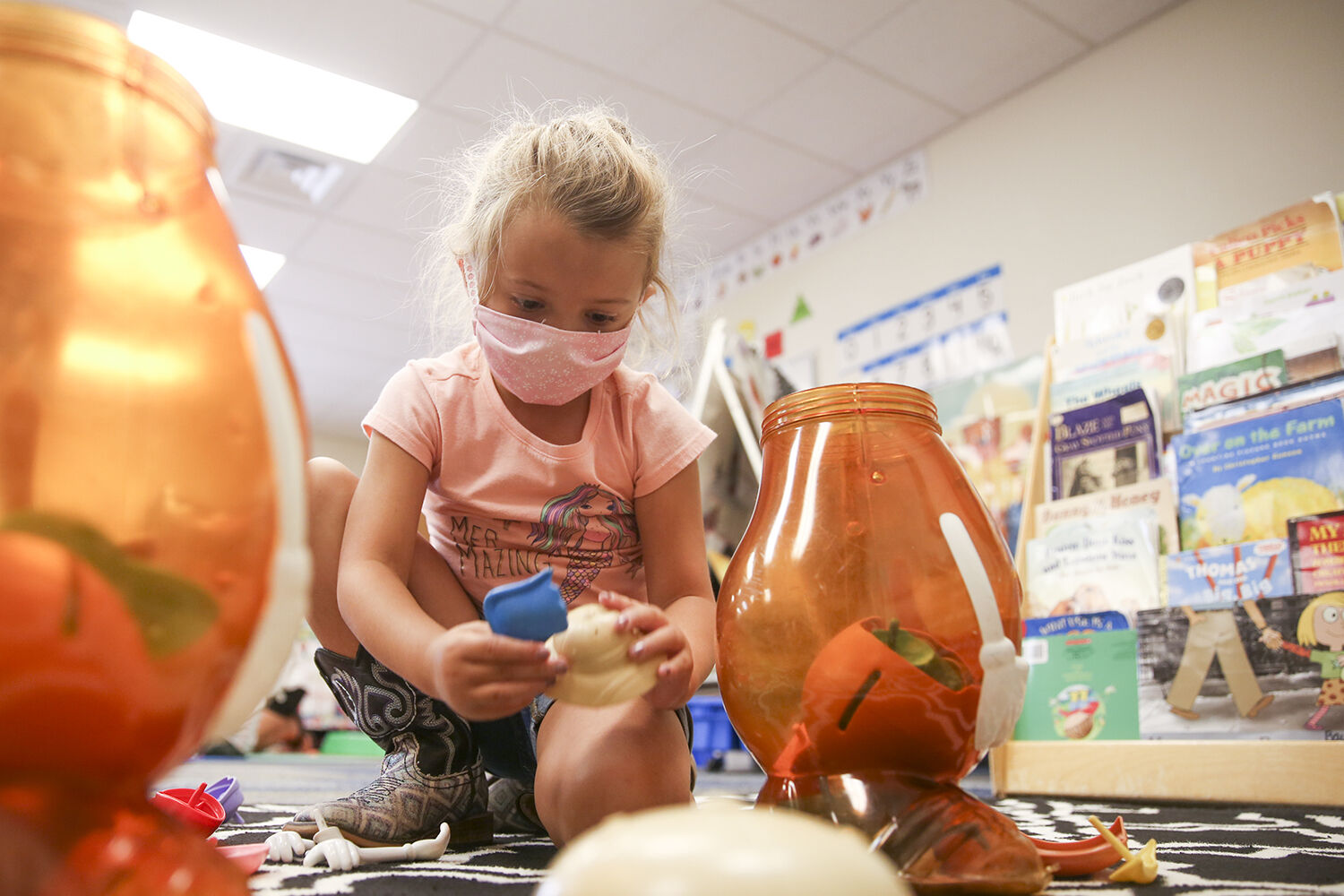 Mackenzie Brennan, 5, helps to put away Mr. Potato Head pieces and parts